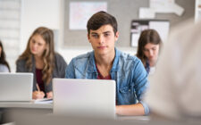 Estudante do ensino médio na sala de aula estudando com seu notebook.