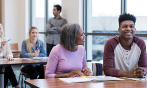 Pais e responsáveis com alunos durante reunião na escola.