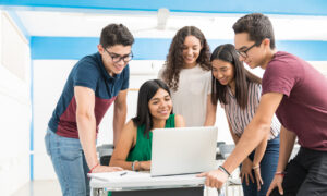 Alunos do ensino médio fazendo trabalho em grupo na sala de aula.