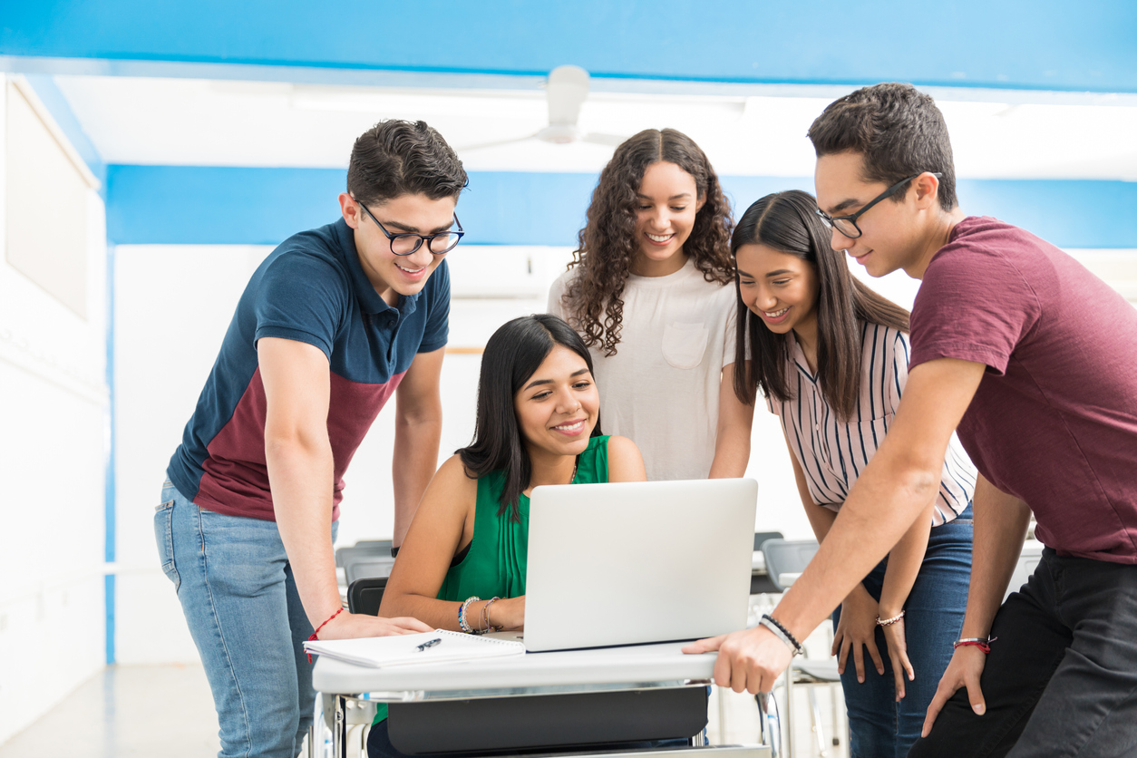 Alunos do ensino médio fazendo trabalho em grupo na sala de aula.